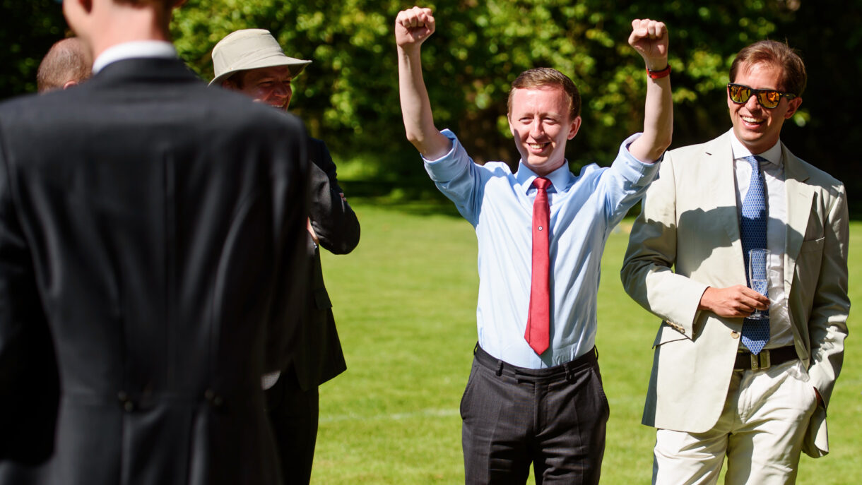 guest at a wedding cheering with his hands up